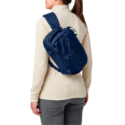 Mujer mostrando la mochila bandolera táctica Lcv8 5.11 en la espalda. Mochila táctica 5.11 ideal para preparación y movilidad urbana.