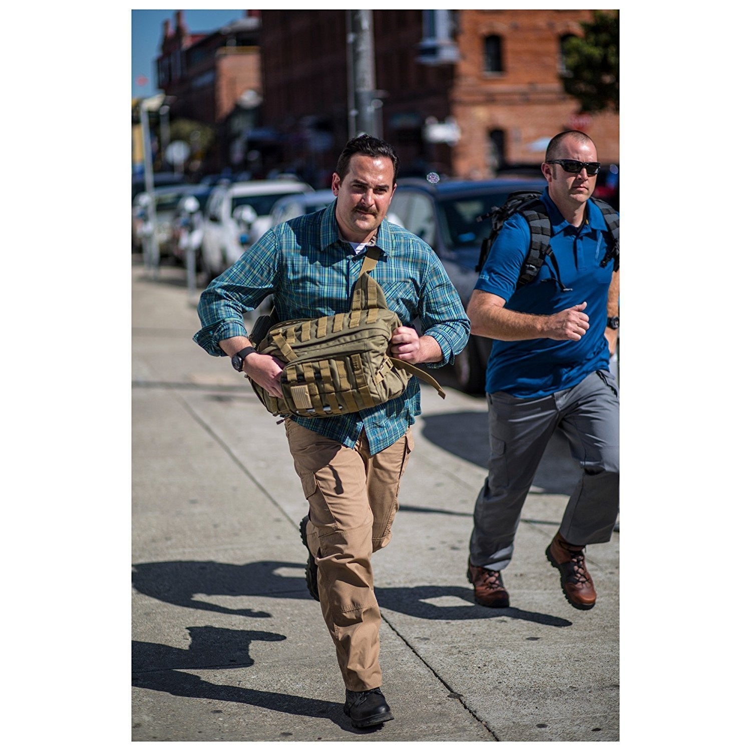 a man in a blue shirt is walking down the street